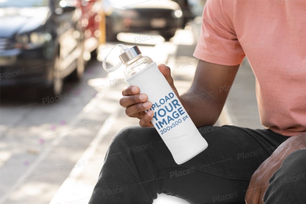 mockup of a bottle in a koozie in hand