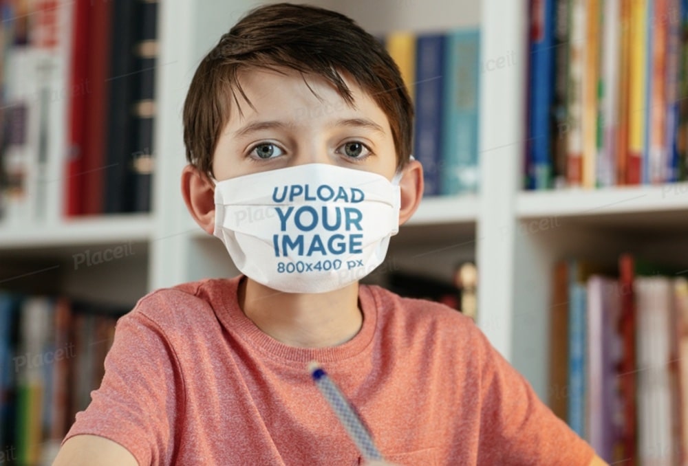 boy with a face mask while doing homework