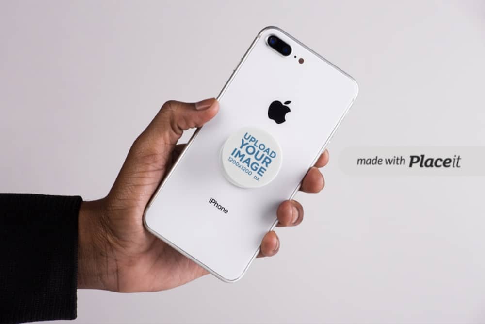 mockup of a male hand holding an iphone with a popsocket