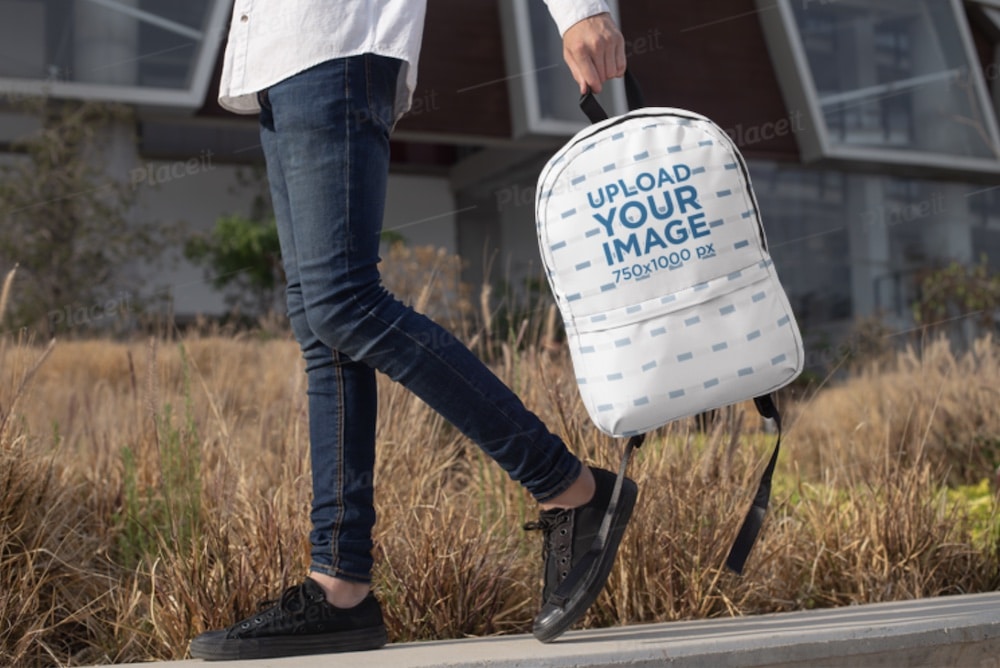 model holding a backpack in hand mockup